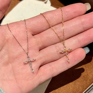 Vue macro détaillée de deux élégants colliers en croix de zircon en argent et en or.