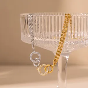 Detailansicht ineinandergreifender Ringe mit Strasssteinen an einer zweifarbigen Kette.