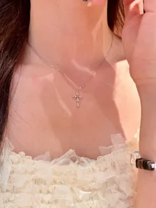 Collier pendentif croix en zircon style français sur mannequin pour un look rétro.
