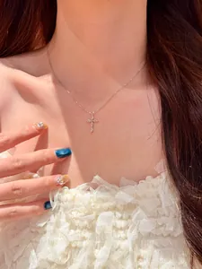 Détail d'un collier à pendentif croix élégant de style français avec des zircons brillants