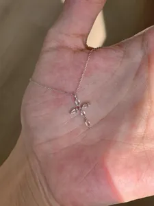 Gros plan détaillé d'un collier pendentif croix en argent avec zircons marquise