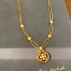Dettaglio della collana placcata oro 24 carati con pendente a fiore in smalto nero e rosso