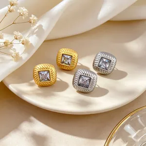 Close-up of minimalist square cubic zirconia earrings in gold and silver finish