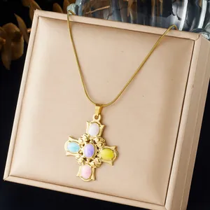 Detailed view of a vintage baroque gold cross necklace featuring vibrant colorful cabochons.