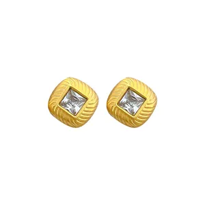 Macro view of square zircon titanium steel earrings featuring a textured golden frame