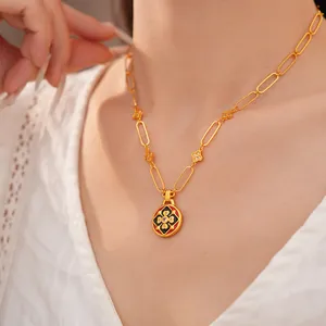 Dettaglio di una collana placcata oro 24K con pendente floreale in smalto su modella