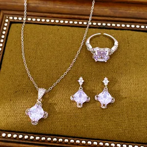 Elegantes Zirkon-Schmuckset mit quadratischen lila Anhängern auf senfgelbem Samt