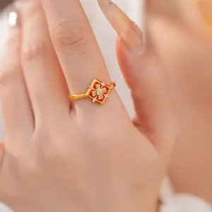 Dettaglio di un anello a fiore placcato oro 24K con smalto rosso e pietre zircone.