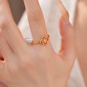 Dettaglio macro di un anello vintage placcato oro 24K con fiore in smalto rosso e zirconi