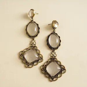 Detailed view of vintage bronze earrings with clear resin oval and diamond-shaped charms