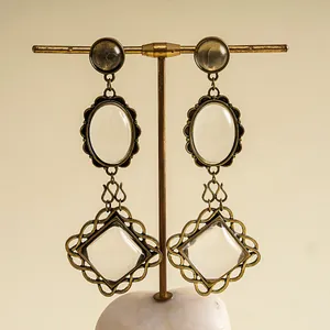 Detail view of vintage oversized earrings with resin stones and ornate metal frames