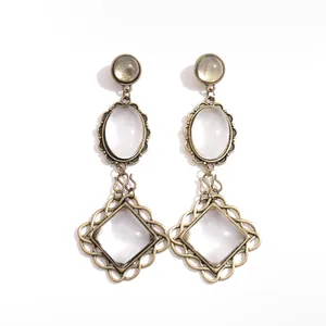 Vintage bronze metal drop earrings featuring oval and square resin stones on white background