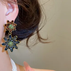Detailed close-up of vintage-style double flower earrings with blue and brown crystals