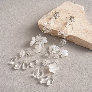 Detailed view of translucent flower tassel earrings with acrylic and glass drops