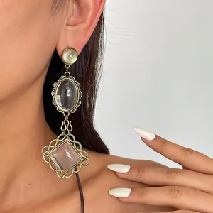 Detailed shot of retro oversized resin earrings with ornate metal lace frames.