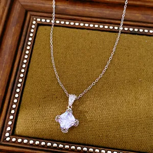 Elegante Halskette mit rhombenförmigem Zirkonia-Anhänger auf antikem Samtrahmen.