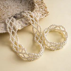 Detail von vintage mehrlagiger Perlenkette und Armband-Set auf Keramikschale präsentiert