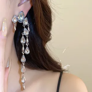 Detail shot of elegant silver needle earrings with shimmering crystal waterdrop tassels