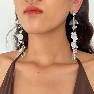 Detailed close-up of translucent acrylic flower and water drop tassel earrings