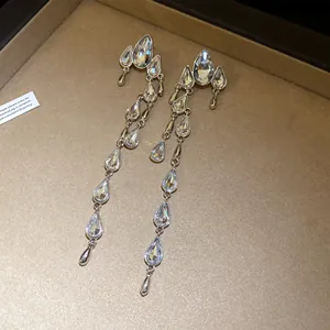Close-up detail of silver long tassel earrings with sparkling water-drop shaped rhinestones