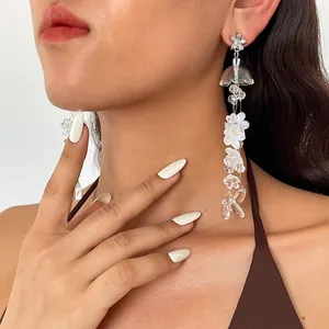 Close-up detail of translucent acrylic flower tassel earrings worn by model