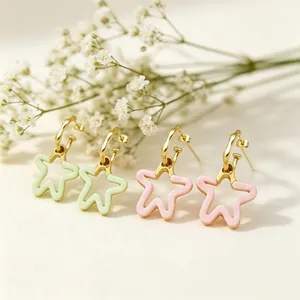 Gros plan de boucles d'oreilles en forme d'étoile avec résine colorée et plaqué or.