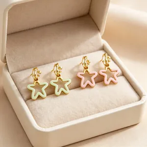 Gros plan de boucles d'oreilles en forme d'étoile dans une boîte à bijoux en velours.