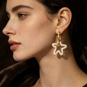 Gros plan d'un mannequin portant des boucles d'oreilles étoile creuse en résine.