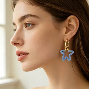 Vue détaillée des boucles d'oreilles étoile évidée en résine bleue, style dopamine.