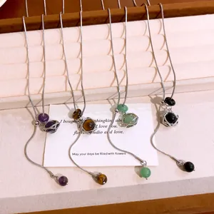 Detail of hexagram star pendant necklaces with purple, brown, green, and black stone beads.