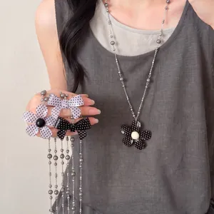 Vintage polkadot bloem en strik ketting met glaskralen voor een minimalistische look