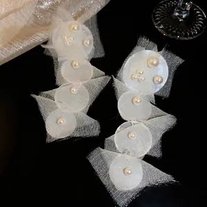 Elegant beach vacation style chiffon earrings with pearls and shells on black background