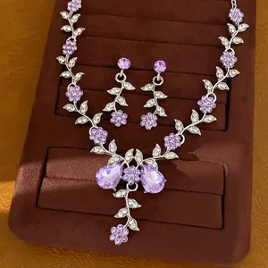 Set di gioielli con collana e orecchini a fiori in strass viola su vassoio