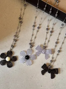 Gedetailleerd overzicht van retro polkadot kettingen met bloem- en strikhangers.