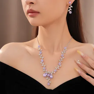 Dettaglio di un set di gioielli floreali viola di lusso indossato da una modella elegante