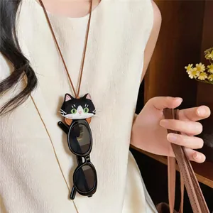 Close-up of cute embroidered cat pendant necklace doubling as a stylish sunglasses holder