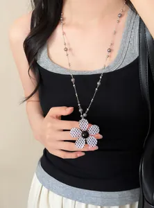 Gedetailleerd overzicht van een retro bloemenketting met grijze kralen op een model