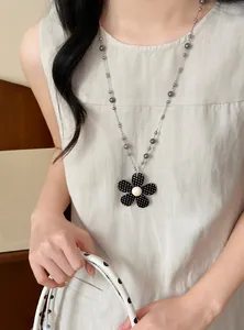 Gedetailleerd overzicht van een vintage bloemenhanger ketting met parel accenten.