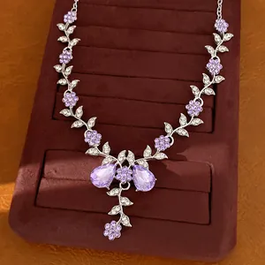 Dettaglio dell'elegante collana con fiori in cristallo viola su supporto in velluto