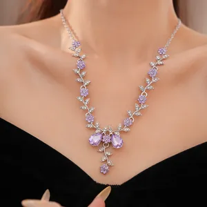Vista dettagliata di una collana con motivi a fiori e foglie in cristallo viola.