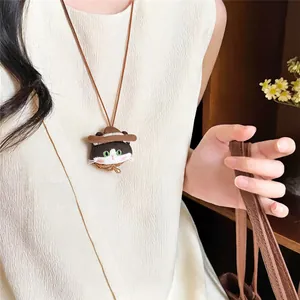 Close-up view of a cute fabric cat pendant necklace worn by a model in a lifestyle setting