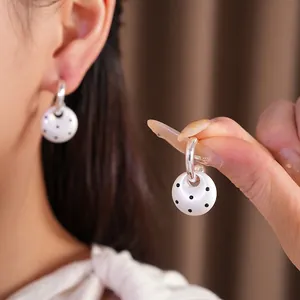 Elegant white enamel hoop earrings with black polka dots and silver needle post for women