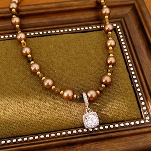 Elegant necklace with brown pearls, tiger eye stones, and a square zircon pendant.