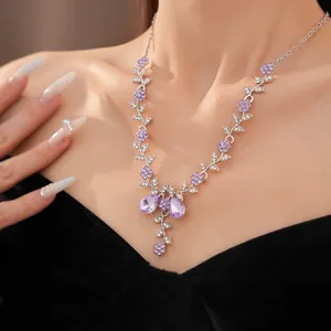Primo piano di un'elegante collana in stile palazzo con fiori di cristallo viola e foglie