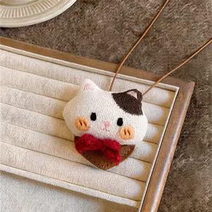 Detailed macro shot of the knitted cat pendant necklace with red bow decoration