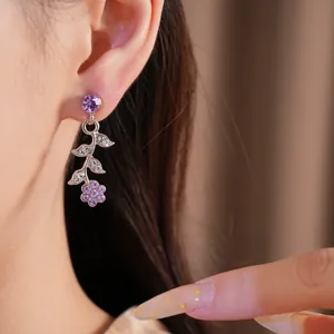 Dettaglio di un orecchino a fiore e foglia con strass viola in squisito stile di corte