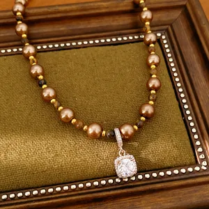 Detail van vintage kralenketting met tijgeroogparels en een vierkante zirkonia hanger