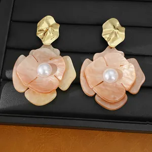 High-quality detail of elegant pleated acrylic flower earrings with faux pearl centers