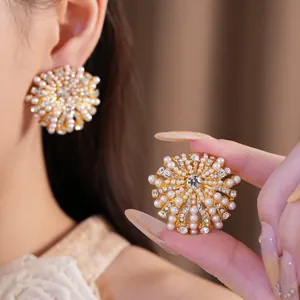 Detailansicht eleganter runder Perlenohrringe in Blumenform mit glitzernden Steinen