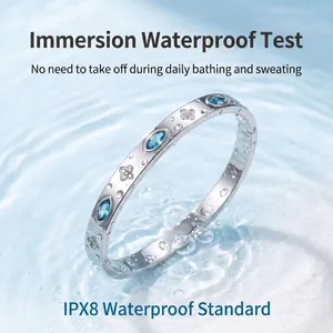 Macrodetail van waterdichte roestvrijstalen armband met blauw oog en klavertjevier-motieven